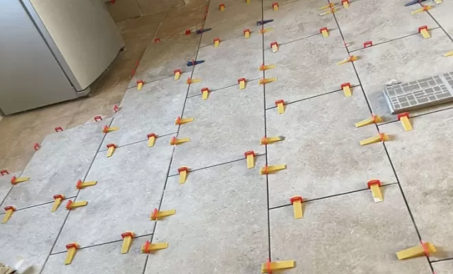 Pose du travertin avec des cales pour un sol parfaitement de niveau  
